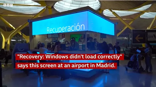 A screen at an airport in Spain with a blue screen as seen on BBC news.